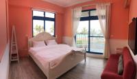 a bedroom with orange walls and a bed and a window at White Sand Homestay in Hualien City