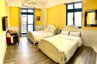 two beds in a room with yellow walls at White Sand Homestay in Hualien City