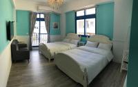two beds in a room with blue walls at White Sand Homestay in Hualien City
