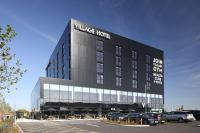 Un gran edificio con coches aparcados en un estacionamiento. en Village Hotel Southampton Eastleigh, en Southampton
