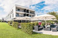 un edificio con sombrillas, sillas y mesas en Schlosshotel Hellenstein, en Heidenheim an der Brenz