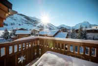 un balcón cubierto de nieve con el sol brillando en una montaña en TERRESENS - Neige et Soleil, en Les Deux Alpes