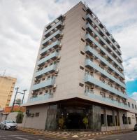 un edificio alto con balcones y un coche aparcado delante en Hotel Marques, en Araras