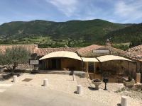 un bâtiment avec deux parasols devant lui dans l&#39;établissement Hotel L&#39;Oustau de la Font, à Reilhanette