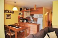 a kitchen and dining room with a table and a kitchen and a kitchen at Apartamento con piscina en Enveitg in Enveitg