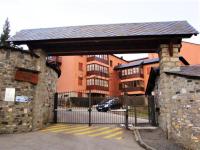 a building with a gate in front of a building at Apartamento con piscina en Enveitg in Enveitg