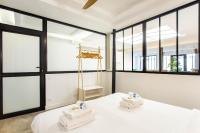 a room with large windows and towels on a bed at CMG Oberkampf - Truillot G in Paris