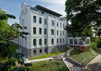 un edificio blanco con una escalera delante en Hotel zwischen den Seen, en Waren