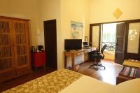 a bedroom with a bed and a desk with a computer at Pousada Vila Tamarindo Eco Lodge in Florianópolis