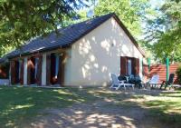 a small white house with two chairs in front of it at Maison de 2 chambres avec jardin clos et wifi a Marcillac la Croisille in Marcillac-la-Croisille