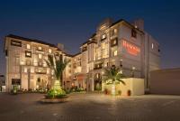Un gran edificio con un cartel al costado. en Ramada by Wyndham Lahore Gulberg II, en Lahore