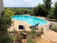 a swimming pool with a table and two chairs in a yard at Maison de 2 chambres avec piscine privee jardin amenage et wifi a Bruniquel in Bruniquel