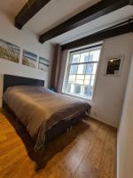 a bedroom with a large bed and a large window at Rijksmonument Havenzicht, met zeezicht, ligging direct aan zee en centrum in Vlissingen