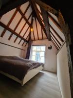 a attic bedroom with a bed and a window at Rijksmonument Havenzicht, met zeezicht, ligging direct aan zee en centrum in Vlissingen