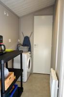 a laundry room with a washing machine and a door at Chalet la lande in Ondres