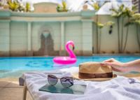 a hat and sunglasses sitting on a table by a pool at Meliá Campinas in Campinas