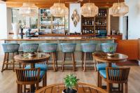 a bar with wooden tables and blue chairs at Kaimana Beach Hotel in Honolulu