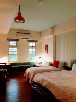 a bedroom with two beds and a couch and windows at MiCarro B&amp;B in Dongshan