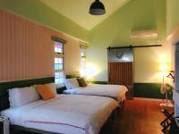two beds in a room with green and yellow walls at MiCarro B&amp;B in Dongshan