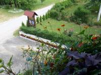 a garden with flowers and a sign on the side of a road at Lake House 1 in Plitvička Jezera