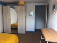 a bedroom with a yellow bed and a mirror at Grand et Charmant 3 pièces Breton Saint Brieuc Centre in Saint-Brieuc