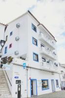 Un edificio blanco con escaleras al frente. en Residencia do Parque, en Odeceixe