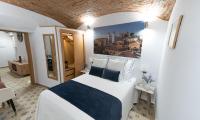Un dormitorio con una cama y un cuadro en la pared. en Suite Cáceres, en Cáceres