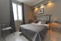 Un dormitorio con una cama grande y una ventana. en Hôtel du Château, en Vincennes