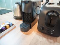 a black appliance sitting on a counter next to a coffee maker at Apparts Limogeanne - Clim - Centre historique in Périgueux