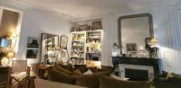 a living room with a couch and a mirror at Appartement type parisien 75m² in Beauvais