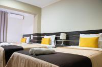 Un dormitorio con dos camas con almohadas amarillas. en Hotel San Martin, en Tarapoto