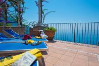 a patio with two blue tables and a fence at Villa Ambra Positano in Positano