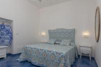 a bedroom with a bed with a bedspread and a chair at Villa Ambra Positano in Positano