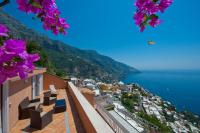 a view of the amalfi coast from a balcony with purple flowers at Villa Ambra Positano in Positano