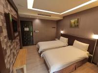 a hotel room with two beds and a table at Jin Yong Quan Spa Hotspring Resort in Wanli District