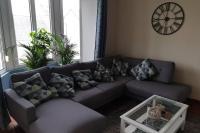 a living room with a couch and a clock on the wall at spa et charme sur la presqu&#39;île de Crozon proximité plages in Telgruc-sur-Mer