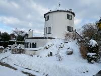 a house with a tower in the snow at De Witte Molen Kranenburg in Kranenburg