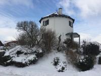 a white building on top of a snow covered hill at De Witte Molen Kranenburg in Kranenburg