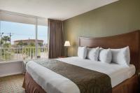 a hotel room with a bed and a large window at Baymont by Wyndham Panama City Beach in Panama City Beach