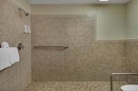 a bathroom with a shower with a tiled shower at Baymont by Wyndham Panama City Beach in Panama City Beach