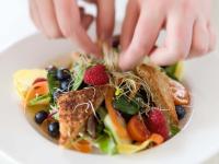 Una persona está alcanzando un plato de comida. en Ammergauer Zeitgeist, en Bad Kohlgrub