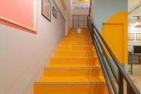 a staircase with orange and yellow stairs in a building at Wonderloft Hostel Kota Tua in Jakarta