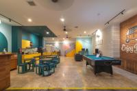 a restaurant with a ping pong table and tables and chairs at Wonderloft Hostel Kota Tua in Jakarta