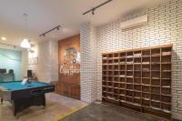 a room with a pool table and a brick wall at Wonderloft Hostel Kota Tua in Jakarta