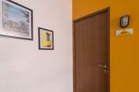 a hallway with a wooden door and pictures on the wall at Wonderloft Hostel Kota Tua in Jakarta