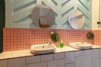 a bathroom with two sinks and two mirrors at Wonderloft Hostel Kota Tua in Jakarta