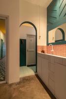 a bathroom with a sink and a mirror and a door at Wonderloft Hostel Kota Tua in Jakarta