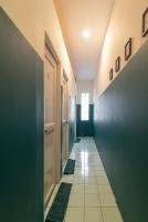 a hallway with a blue wall and a tile floor at Wonderloft Hostel Kota Tua in Jakarta