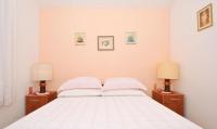 a bedroom with a white bed with two lamps at Apartment Vesna Ciovo in Trogir