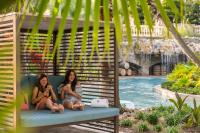 zwei Mädchen auf einer Bank neben einem Pool in der Unterkunft Four Seasons Resort Orlando at Walt Disney World Resort in Orlando